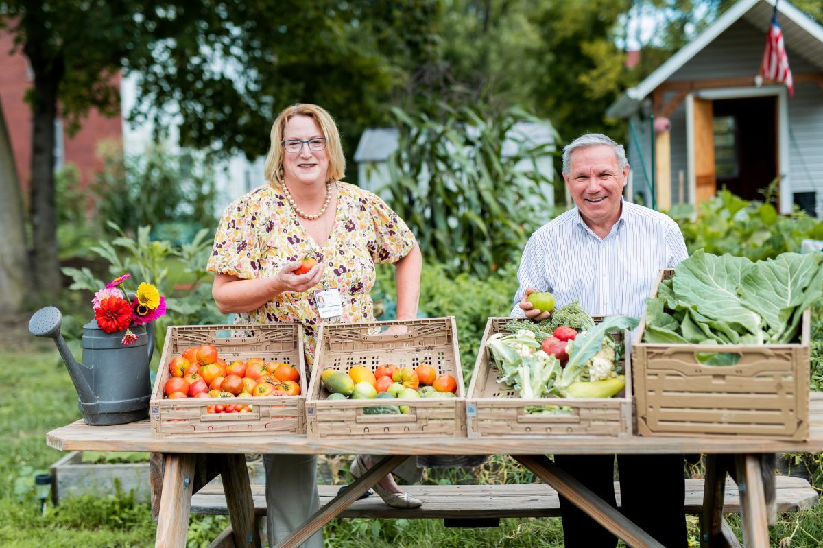 Patti Jackson-Gehris, vice president, Strategy & Business Development, UPMC, and Ron Bonacci, vice president, Advertising and Marketing, Weis Markets, show off some of the recent harvest from UPMC's community garden plots located at the River Valley YMCA in Williamsport.